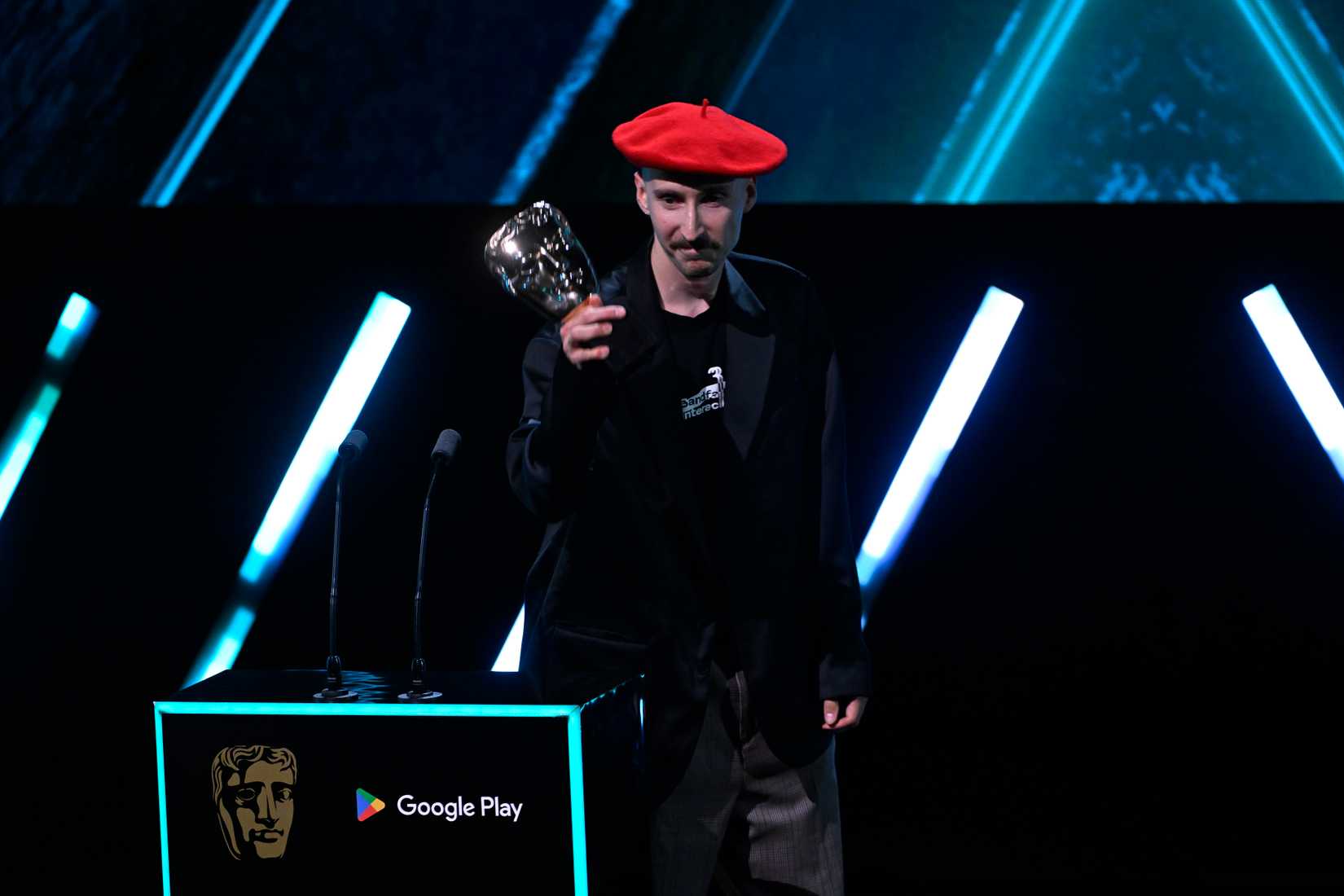 Alexandre Breton in a red beret accepts the BAFTA for Debut Game