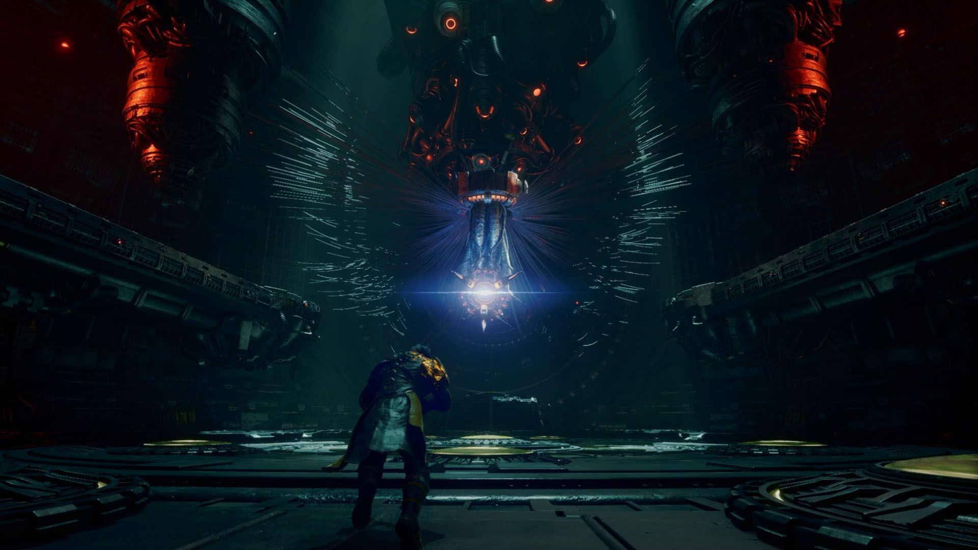A man standing in front of a machine hanging from the ceiling in a dark and metallic room in Saros.