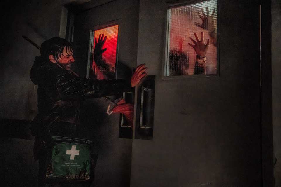 Bryan (Austin Abrams) holds a door from zombies in Resident Evil 2026