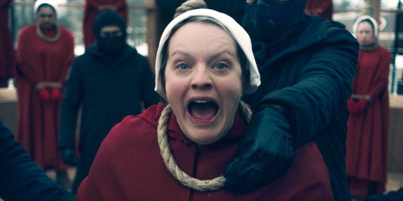 June Osborne (Elisabeth Moss), kneeling as a hangman puts a noose around her neck, shouts for rebellion in The Handmaid's Tale