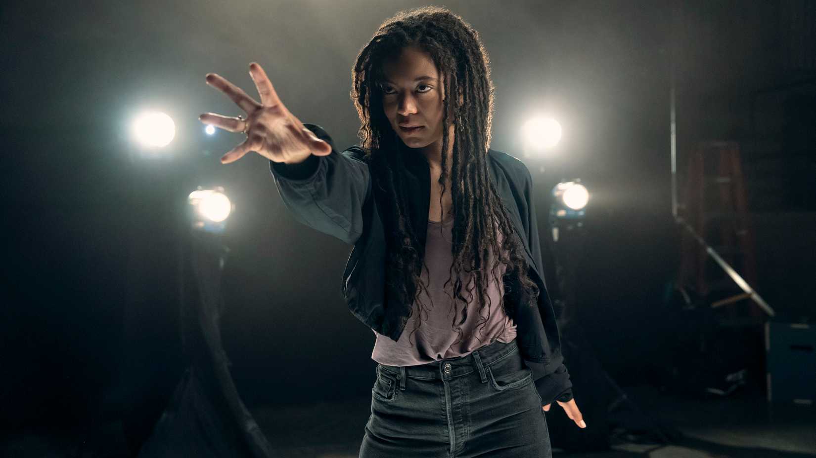 Marie Moreau (Jaz Sinclair) reaches out her hand to use her powers while spotlights shine behind her in Gen V