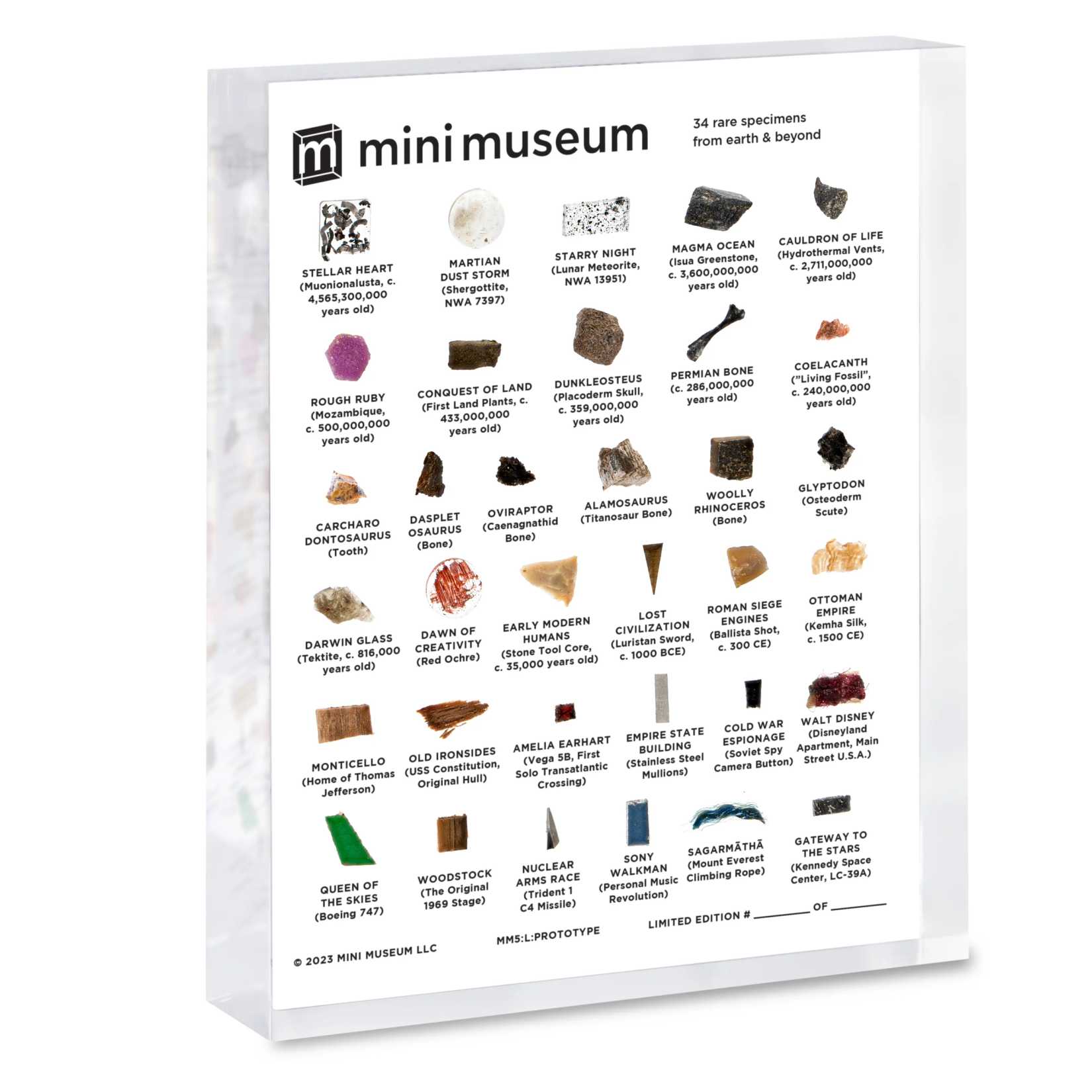 A photo of the 5th Edition of Mini Museum, a 4-by-5-inch acrylic block containing a grid of 34 tiny samples of items, including dinosaur bones, a piece of one of Amelia Earhart's planes, a fragment of a U.S. battleship, and a lot more