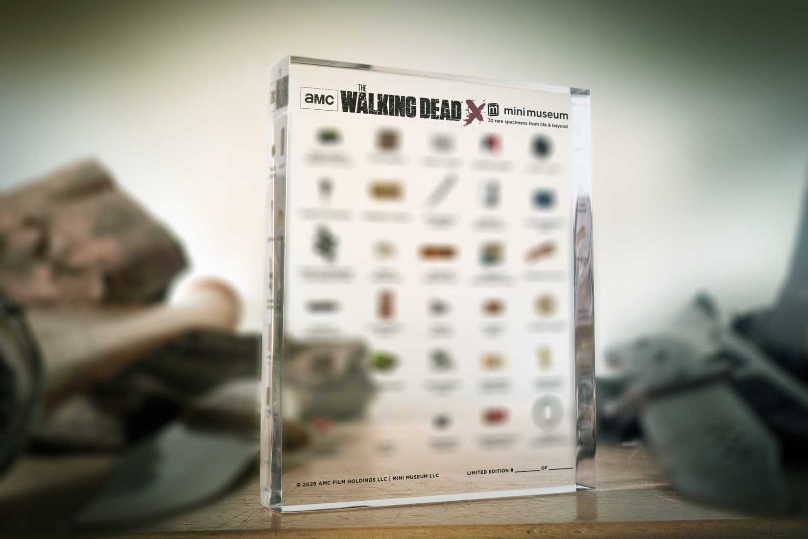 Concept art for a Mini Museum — a 4-by-5-inch acrylic block full of tiny 5mm square pieces of artifacts — devoted to The Walking Dead. The details of which props are included is blurred out.