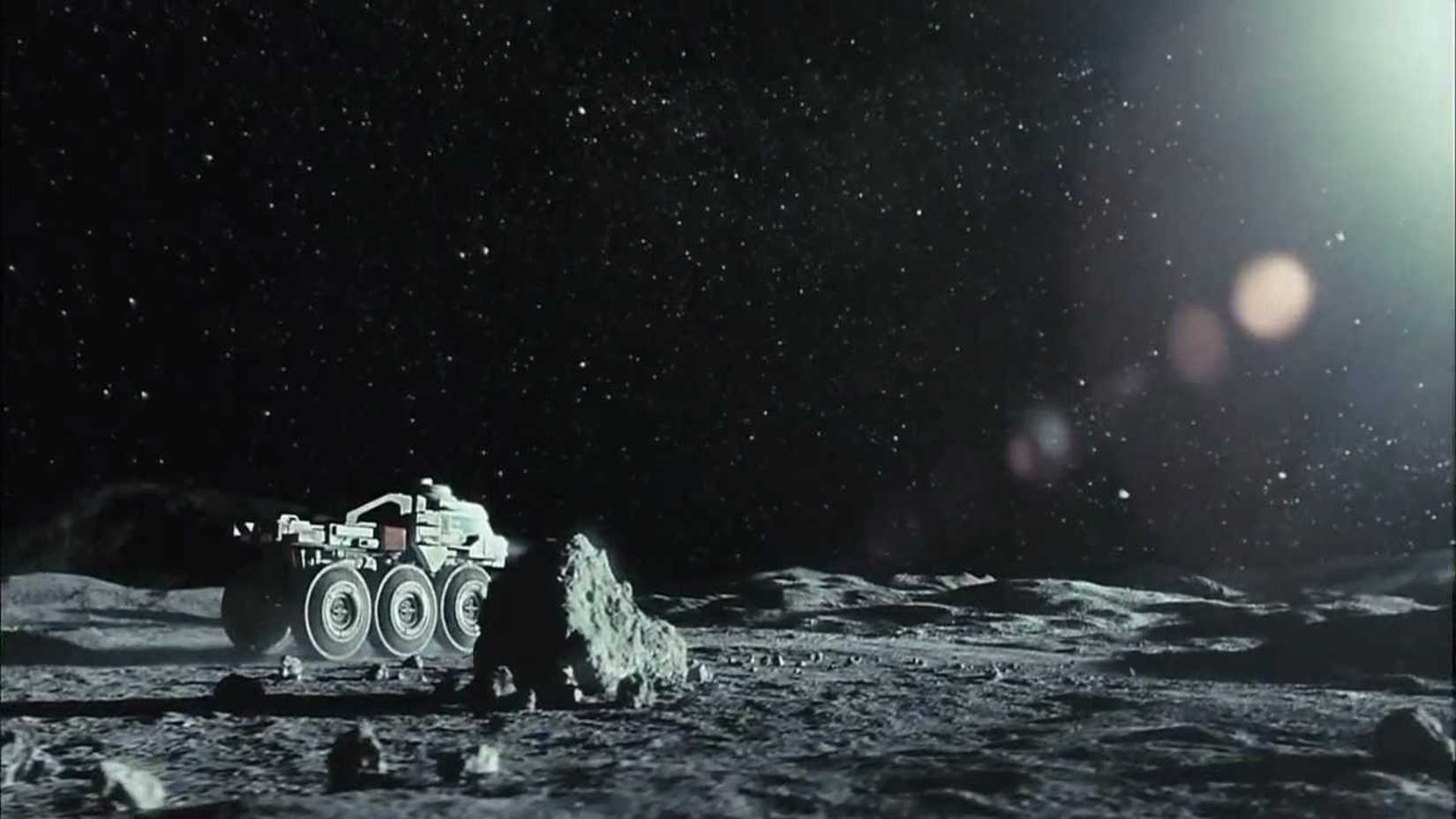 Still from the movie Moon featuring a lunar vehicle riding along the surface of the moon. 