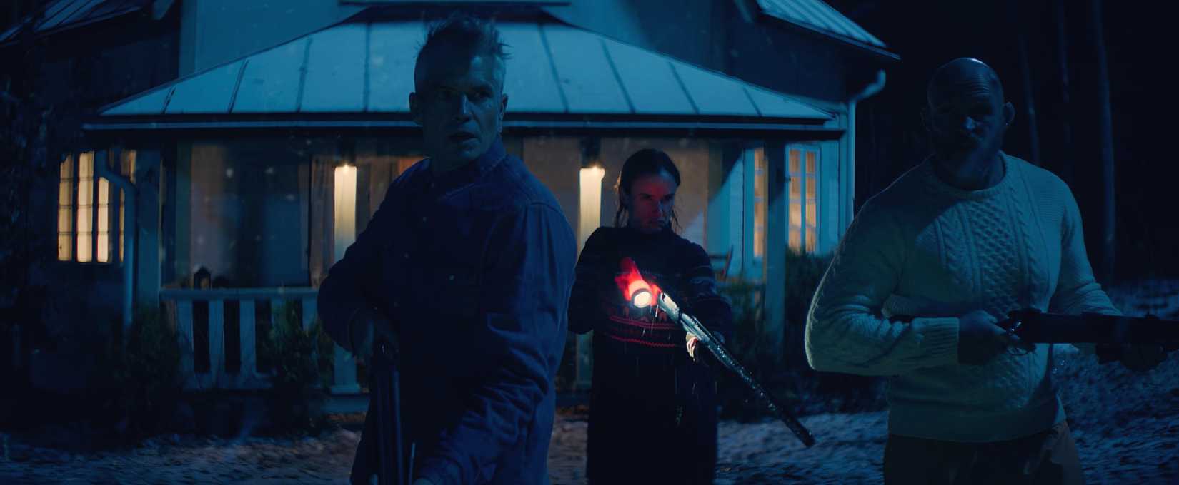 Timothy Olyphant , Juliette Lewis, and Keith Jardine, all holding guns, cross in front of a lit-up house at night in Over Your Dead Body