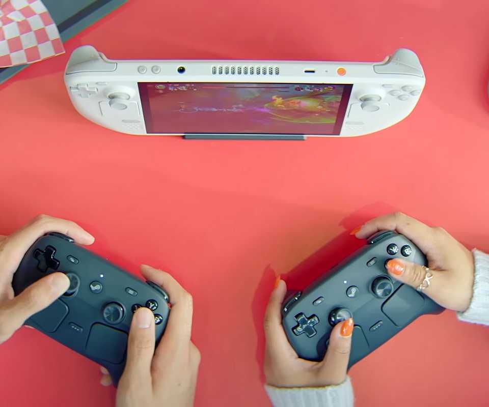 A still of two players using Steam Controllers to play on a handheld PC