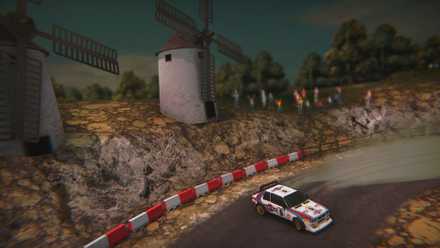 A cel-shaded Lancia Delta powerslides past windmills in Super Woden: Rally Edge