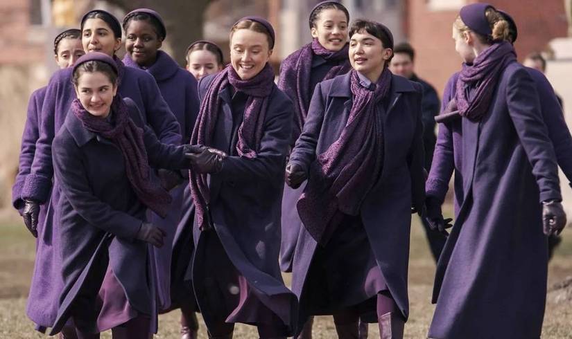 Young, smiling girls dressed in purple in The Testaments