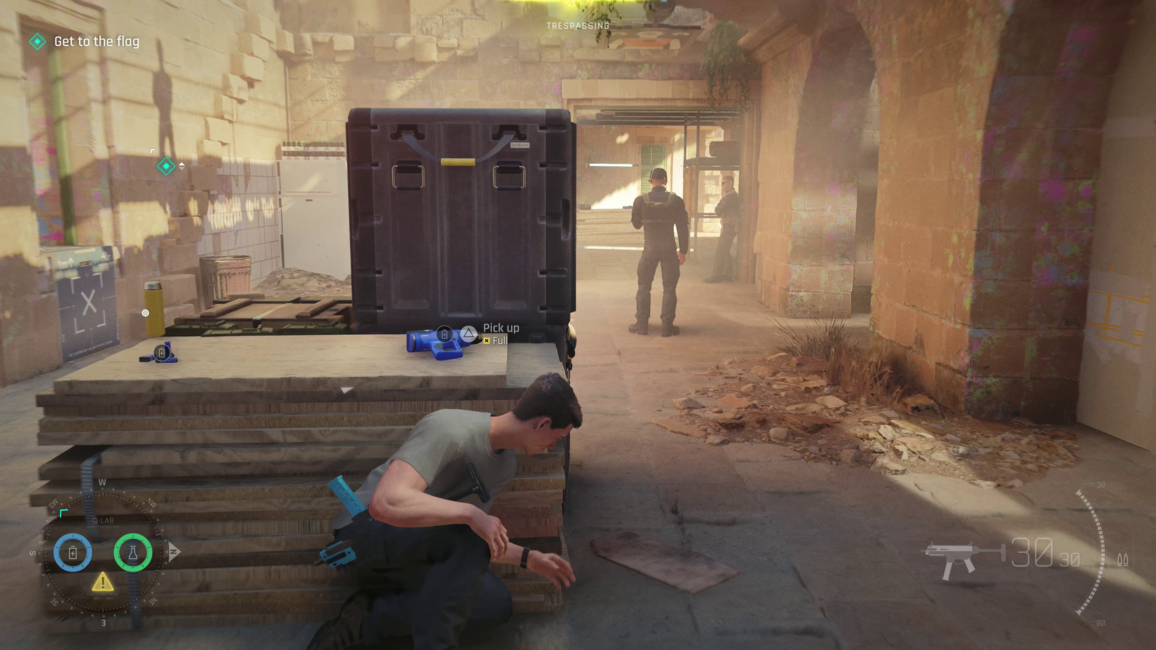 James Bond crouches behind some building materials in a ruined castle patrolled by guards