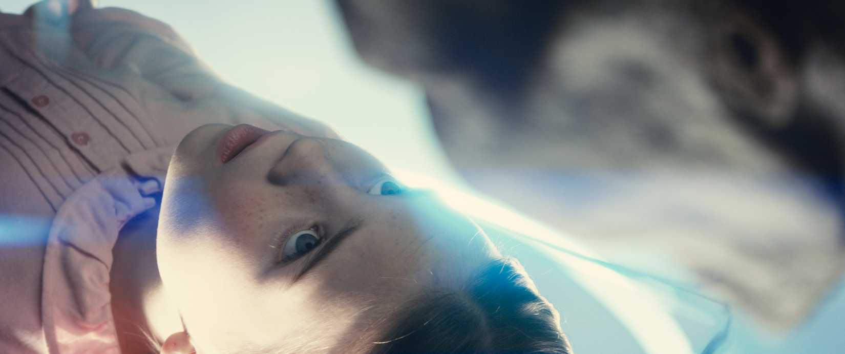 Girl laying on glowing table in Disclosure Day
