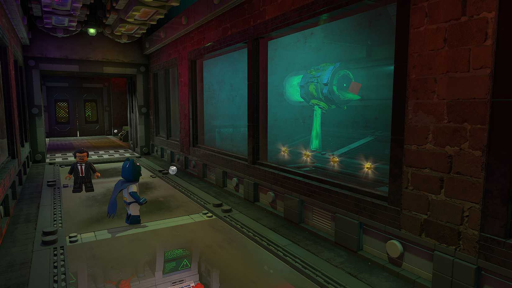 Uma captura de tela de Lego Batman: Legacy of the Dark Knight mostrando Batman parado em frente a grandes janelas olhando para um cano na outra sala. Dentro do cano há um tijolo vermelho