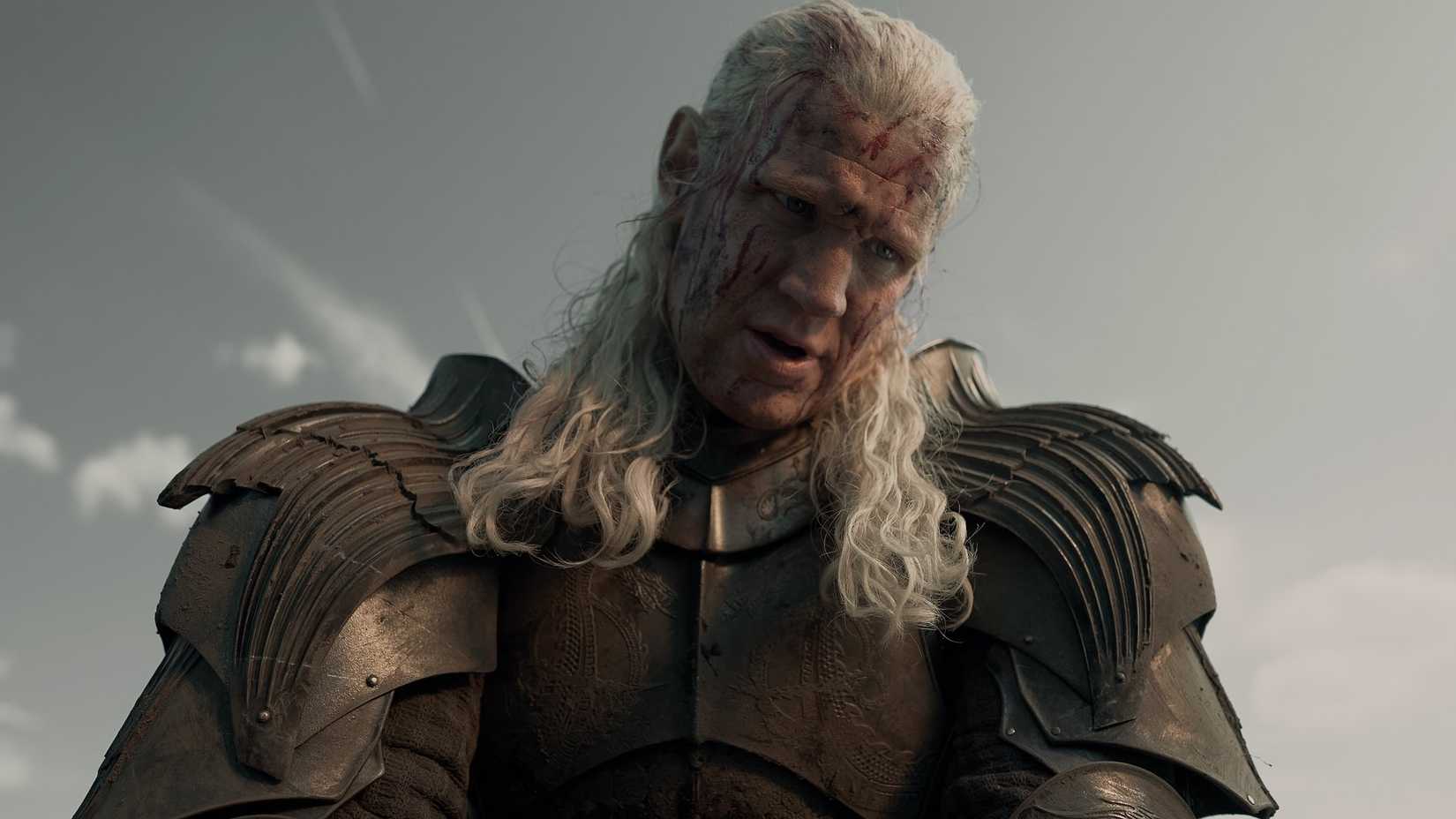 Daemon Targaryen (Matt Smith) wears armor and looks down with his face streaked with blood in House of the Dragon season 3.