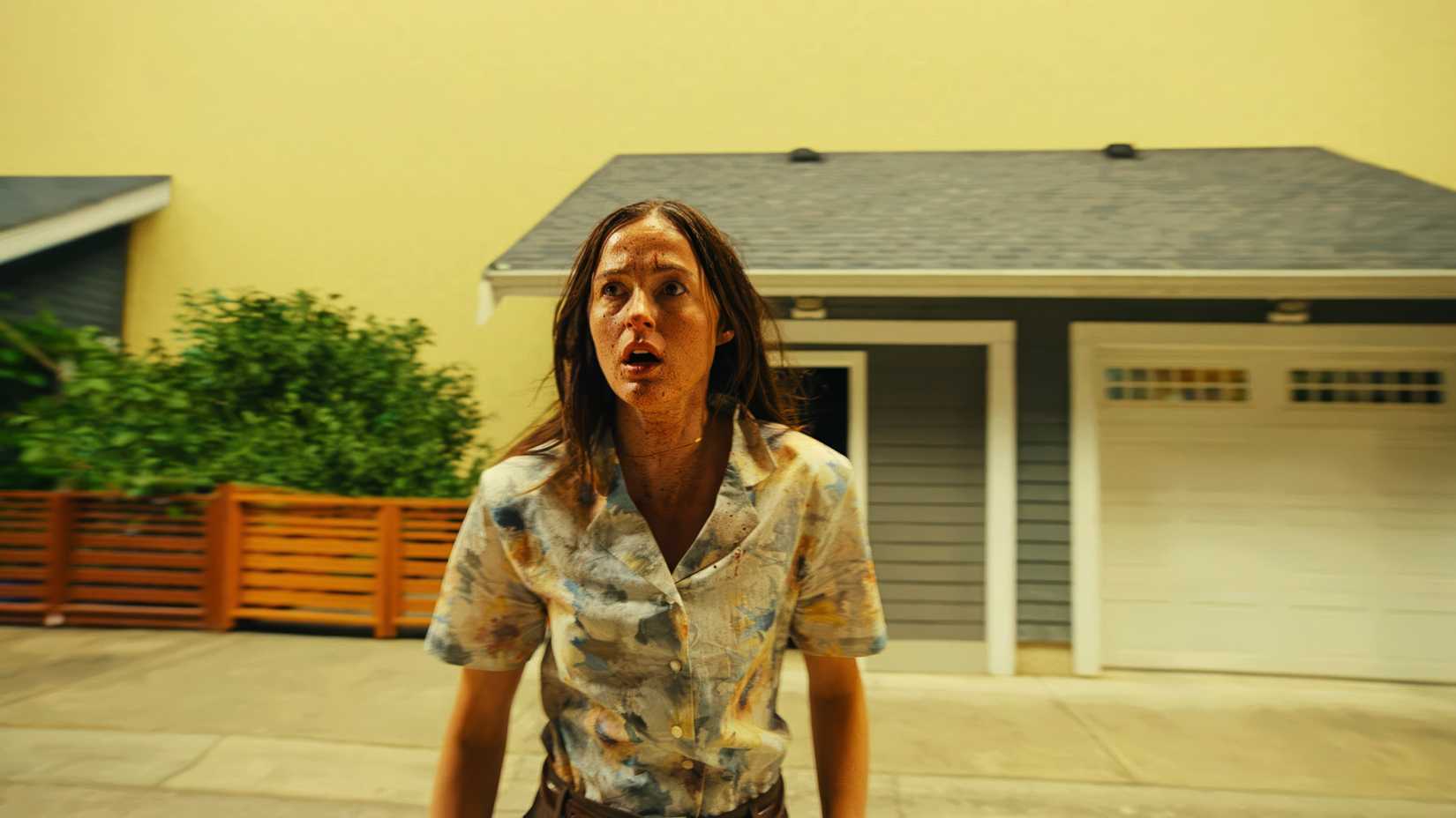 Mary (Renate Reinsve) looking visibly shaken in front of a garage.