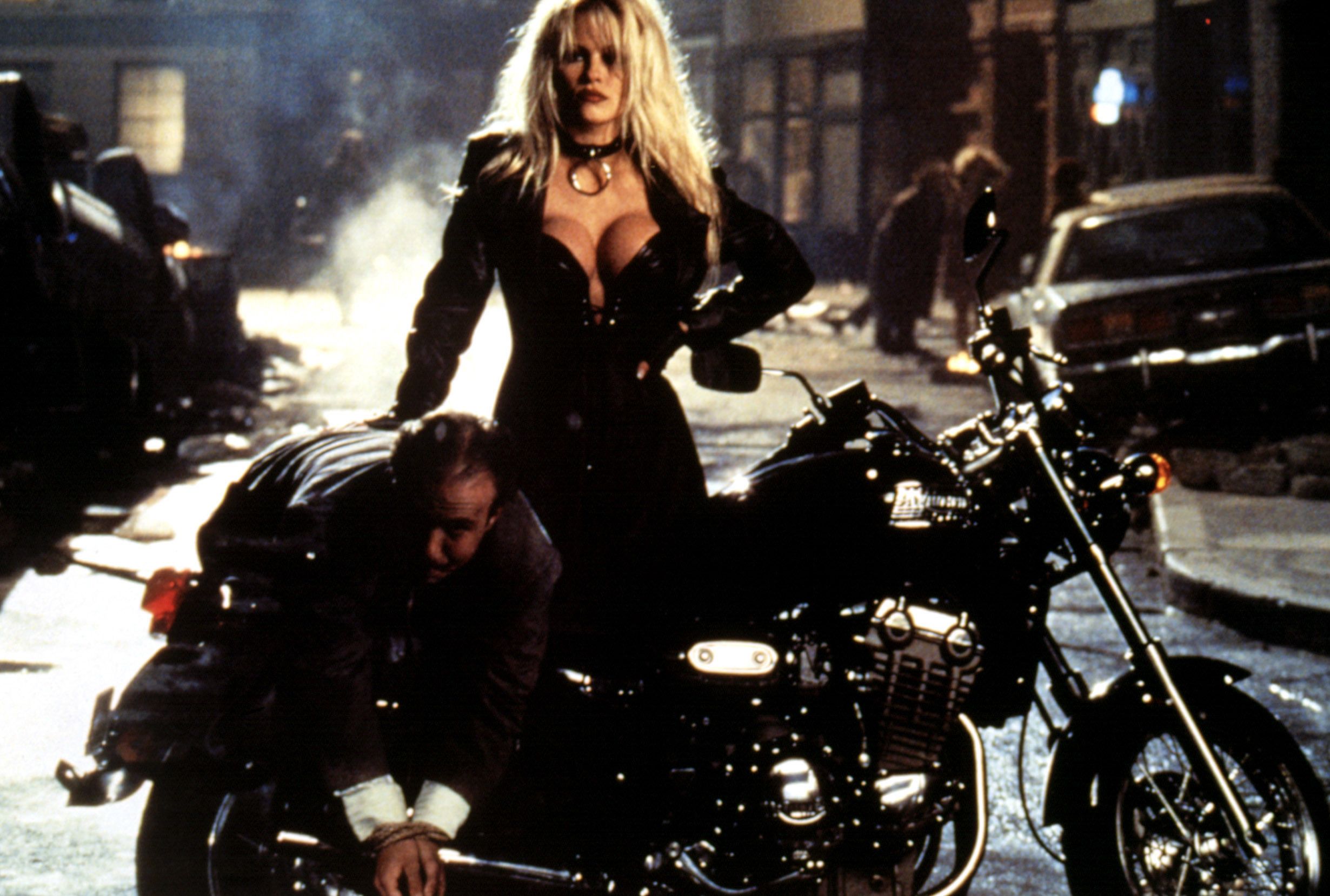 Barb Wire with a criminal on the back of her motorcycle