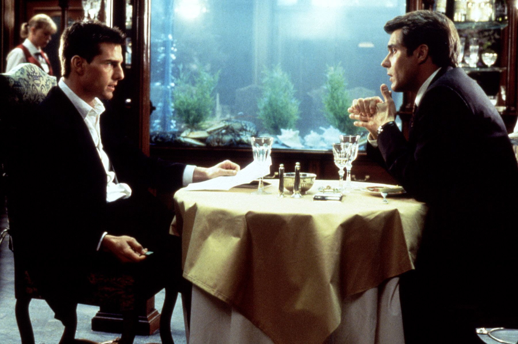 Tom Cruise facing Henry Czerny in a restaurant