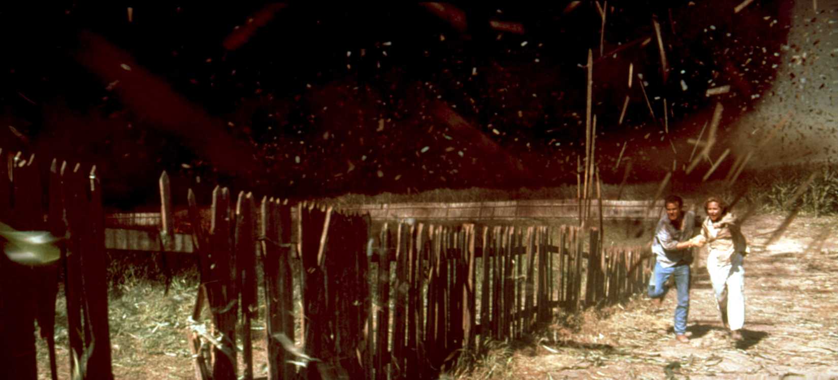 A huge black tornado obliterates the screen while Helen Hunt and Bill Paxton run toward the camera