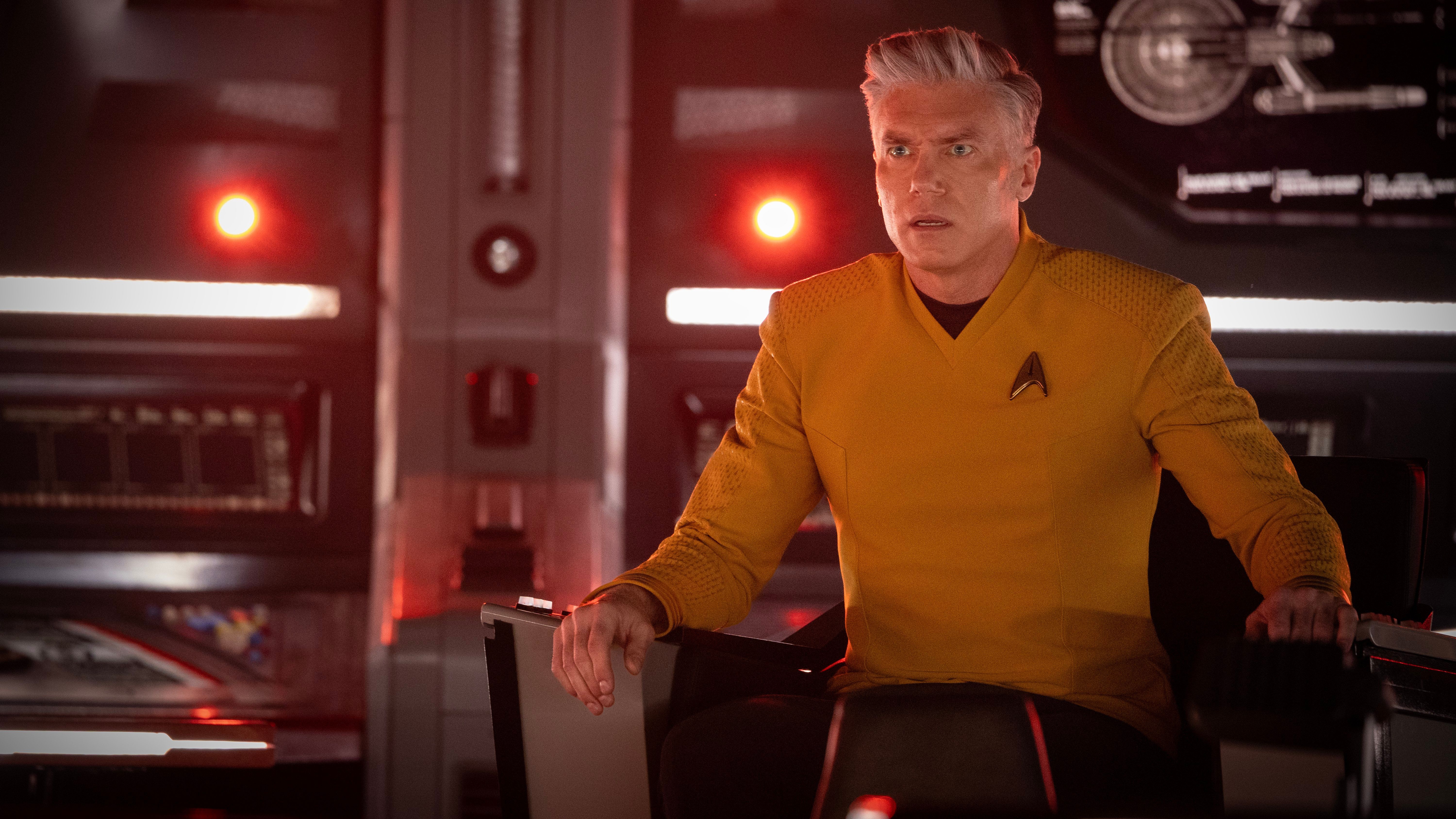 Captain Pike (Anson Mount) sits in the captain's chair on the Enterprise looking worried in Star Trek: Strange New Worlds season 4.