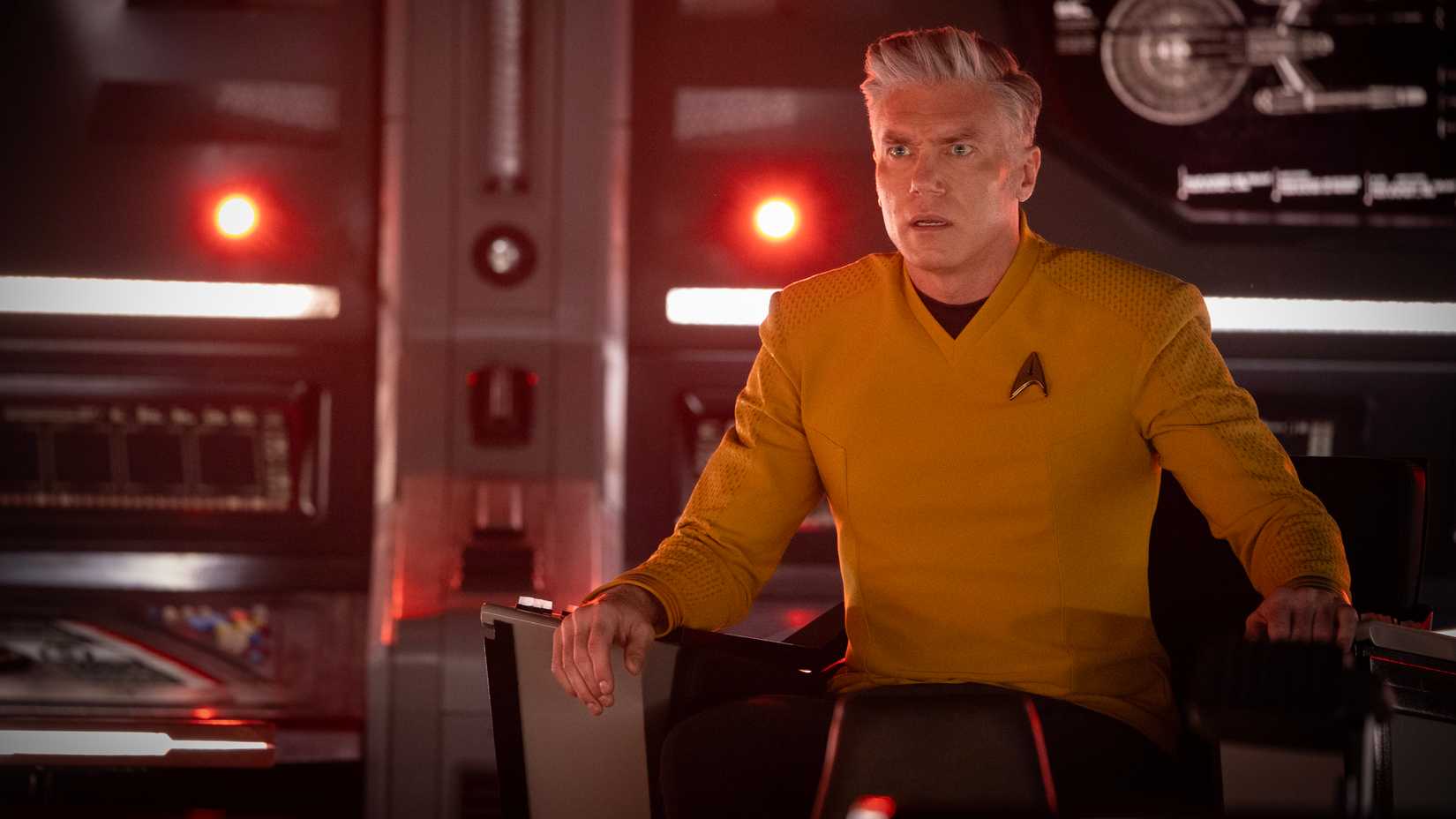 Captain Pike (Anson Mount) sits in the captain's chair on the Enterprise looking worried in Star Trek: Strange New Worlds season 4.