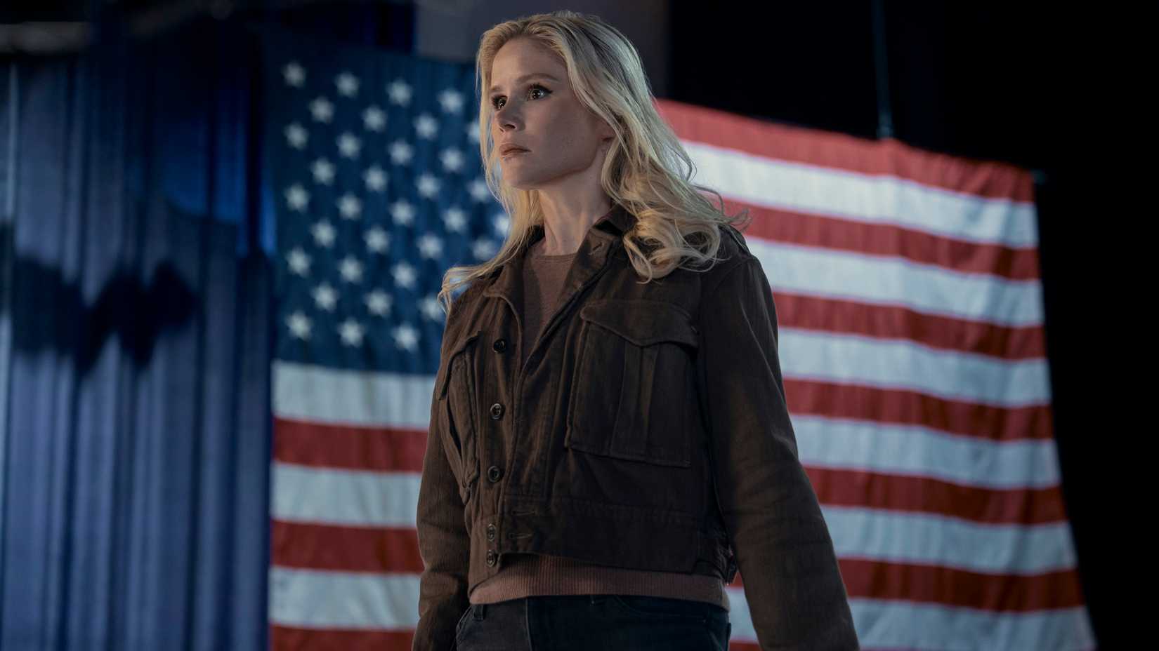 Annie January (Starlight) standing resolutely against the backdrop of an American flag.