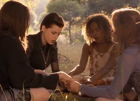 Four teen girls do witchcraft in a sunny field