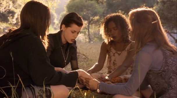 Four teen girls do witchcraft in a sunny field