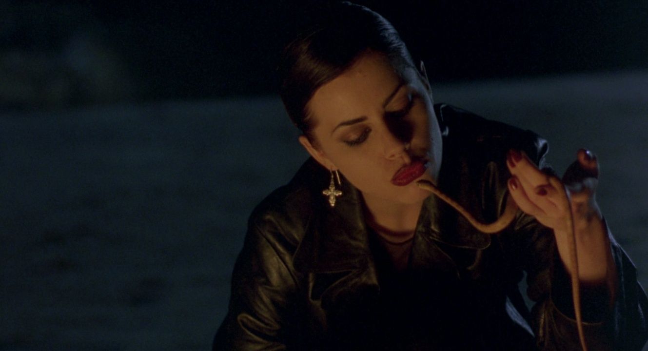 A teen girl in a leather jacket plays with a snake in The Craft 1996