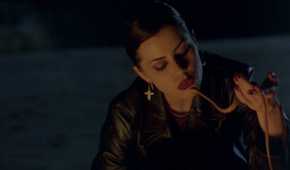 A teen girl in a leather jacket plays with a snake in The Craft 1996