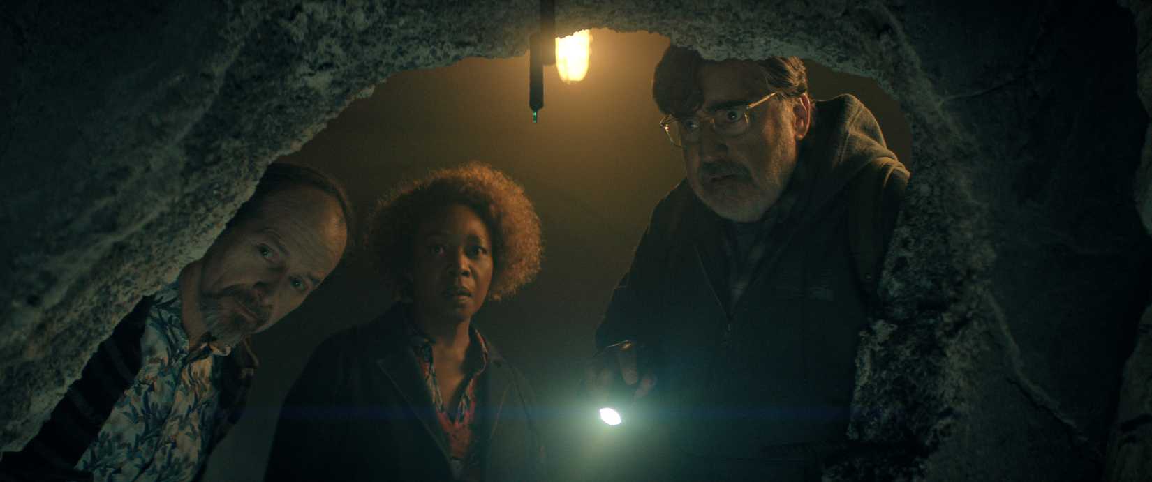 A screenshot of Denis O'Hare, Alfre Woodard and Alfred Molina staring down a dark tunnel.