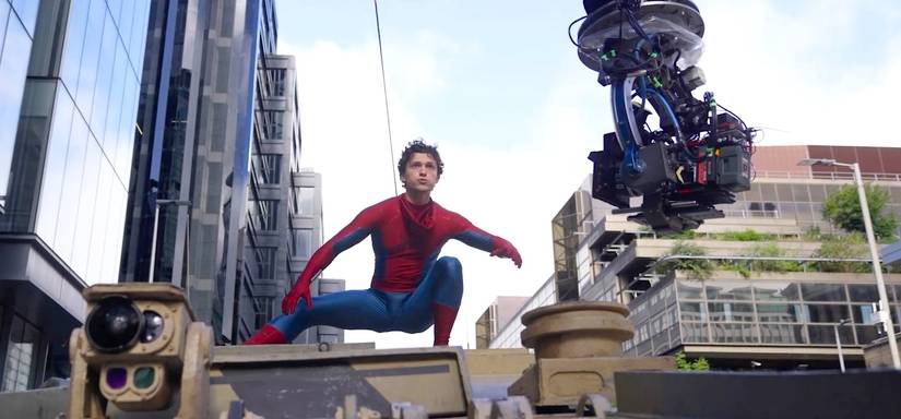 Tom Holland riding on a tank in Brand New Day while a big camera shoots next to him