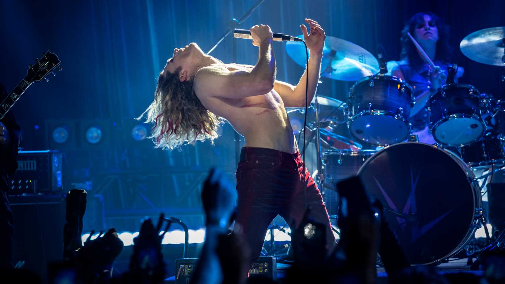 Lestat (Sam Reid) throws his head back while singing on stage shirtless in The Vampire Lestat.