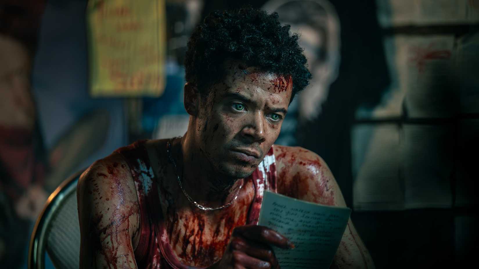 Louis (Jacob Anderson) sits drenched in blood holding a handwritten note in The Vampire Lestat.