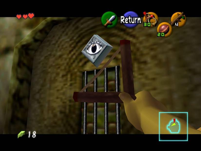 A hand with a slingshot aimed toward an eye on a wall in Ocarina of Time.
