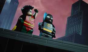 Lego Batman Legacy of the Dark Knight Batman and Robin standing on a rooftop in a parody of BTAS opening