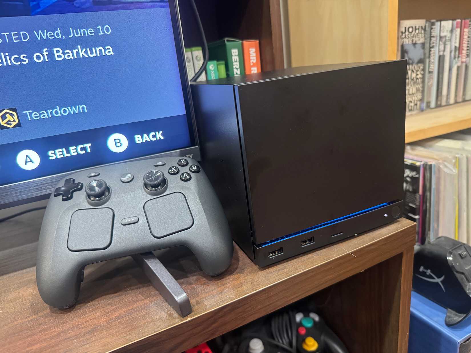 A Steam Controller sits next to a Steam Machine.
