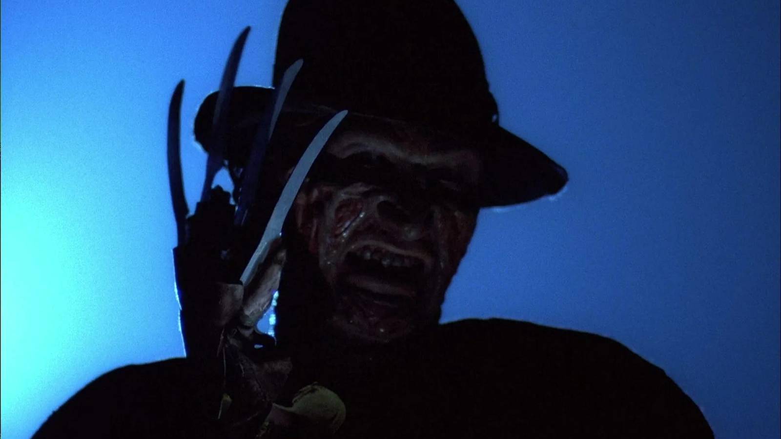 Freddy Krueger trong chiếc mũ phớt biểu tượng, tạo dáng với những ngón tay lưỡi dao sắc nhọn