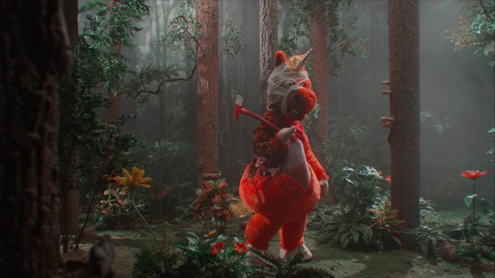 A bloody and bandaged mascot univorn holds and axe, still from Buddy movie
