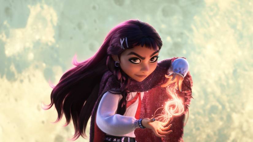 Billie stands with the moon in the background shaping magic sparks in her hands in Hexed.