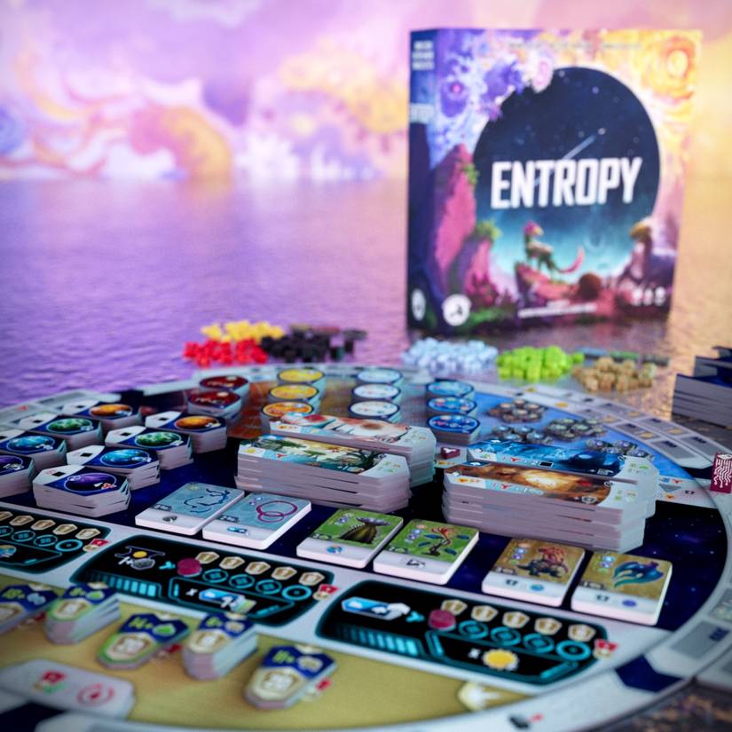 The box of Entropy is in the background of an image showing the board and components laid out
