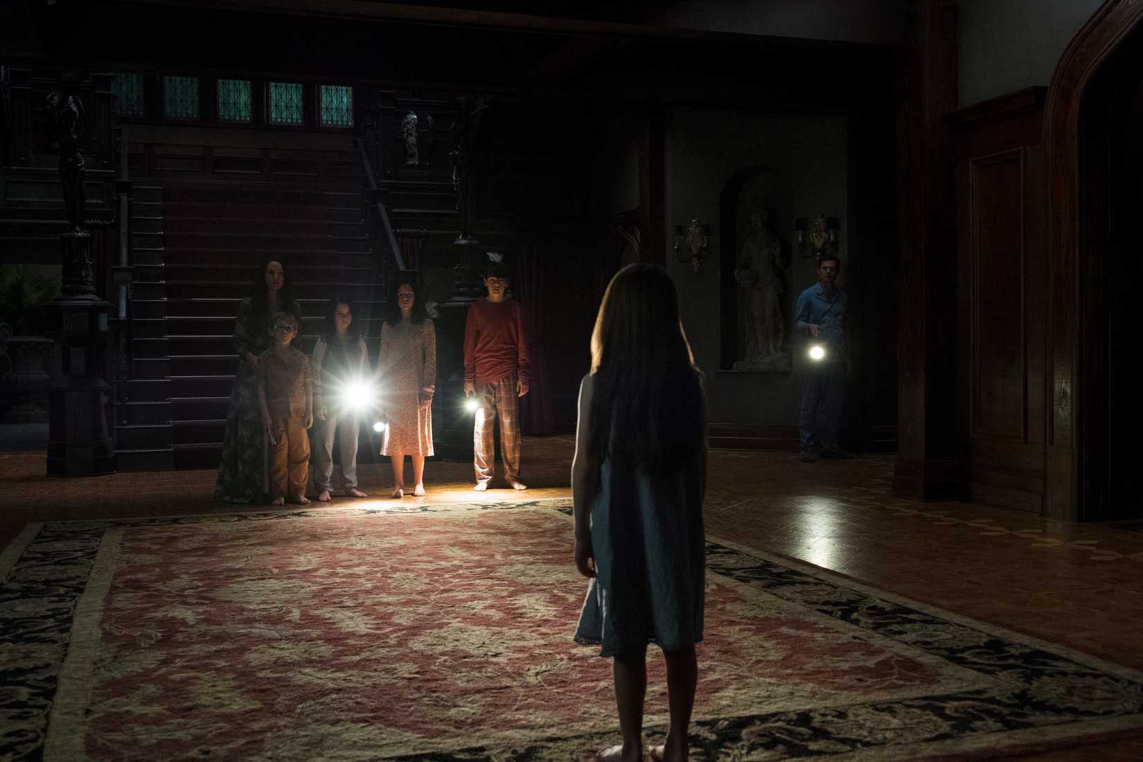 A young Nelly stares at the rest of her family in The Haunting of Hill House