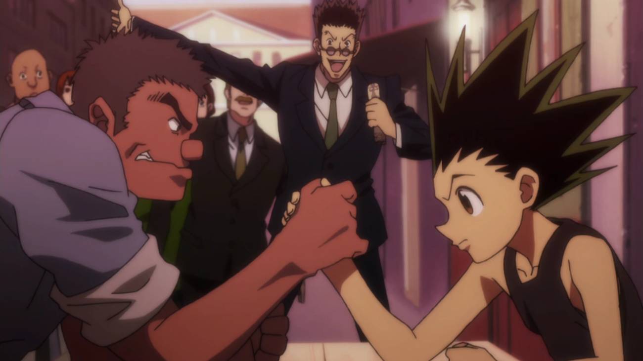 Gon arm wrestles a stranger for money while Leorio cheers him in Hunter x Hunter