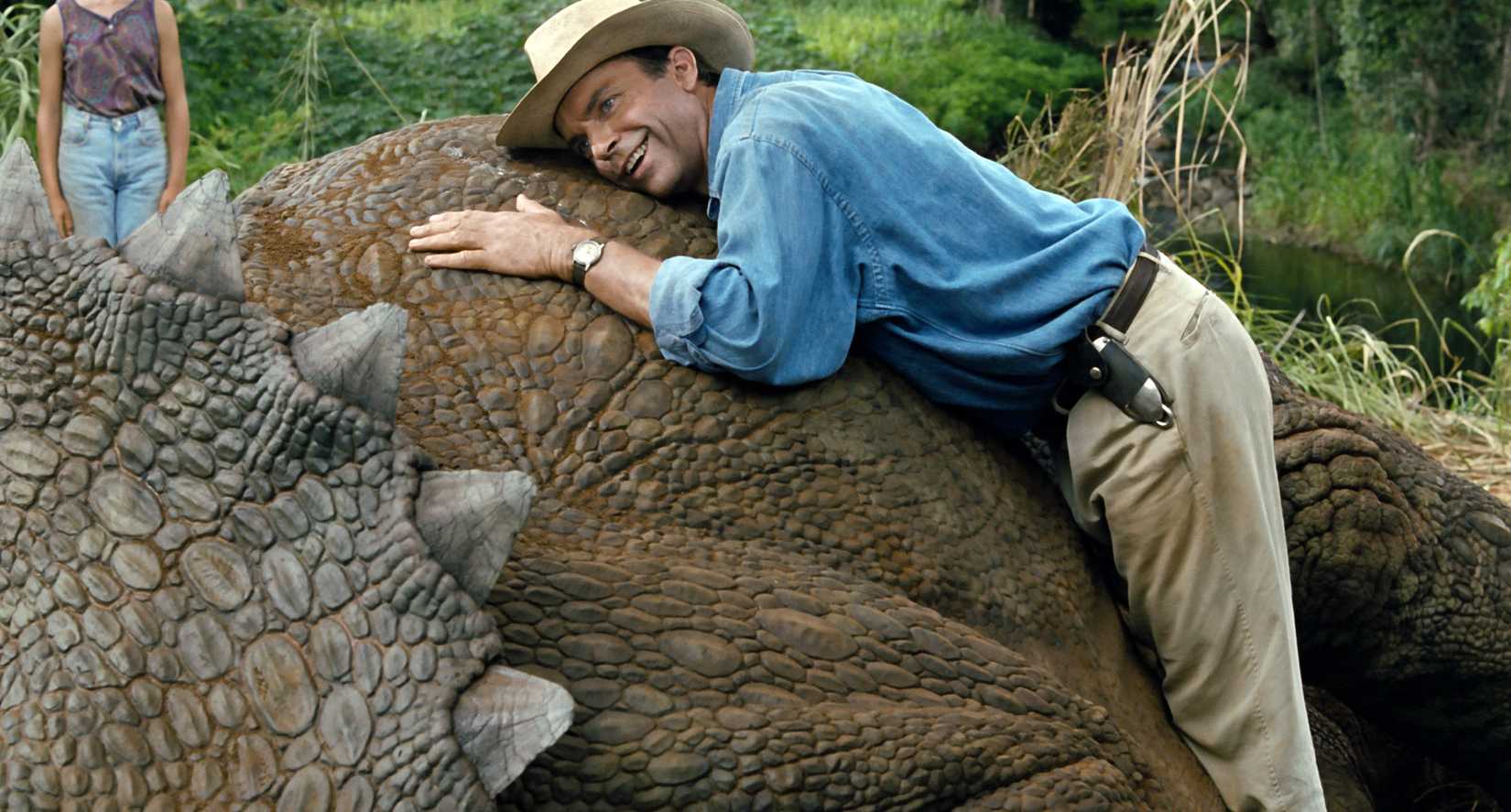 Sam Neill mỉm cười khi lắng nghe hơi thở của một chú khủng long