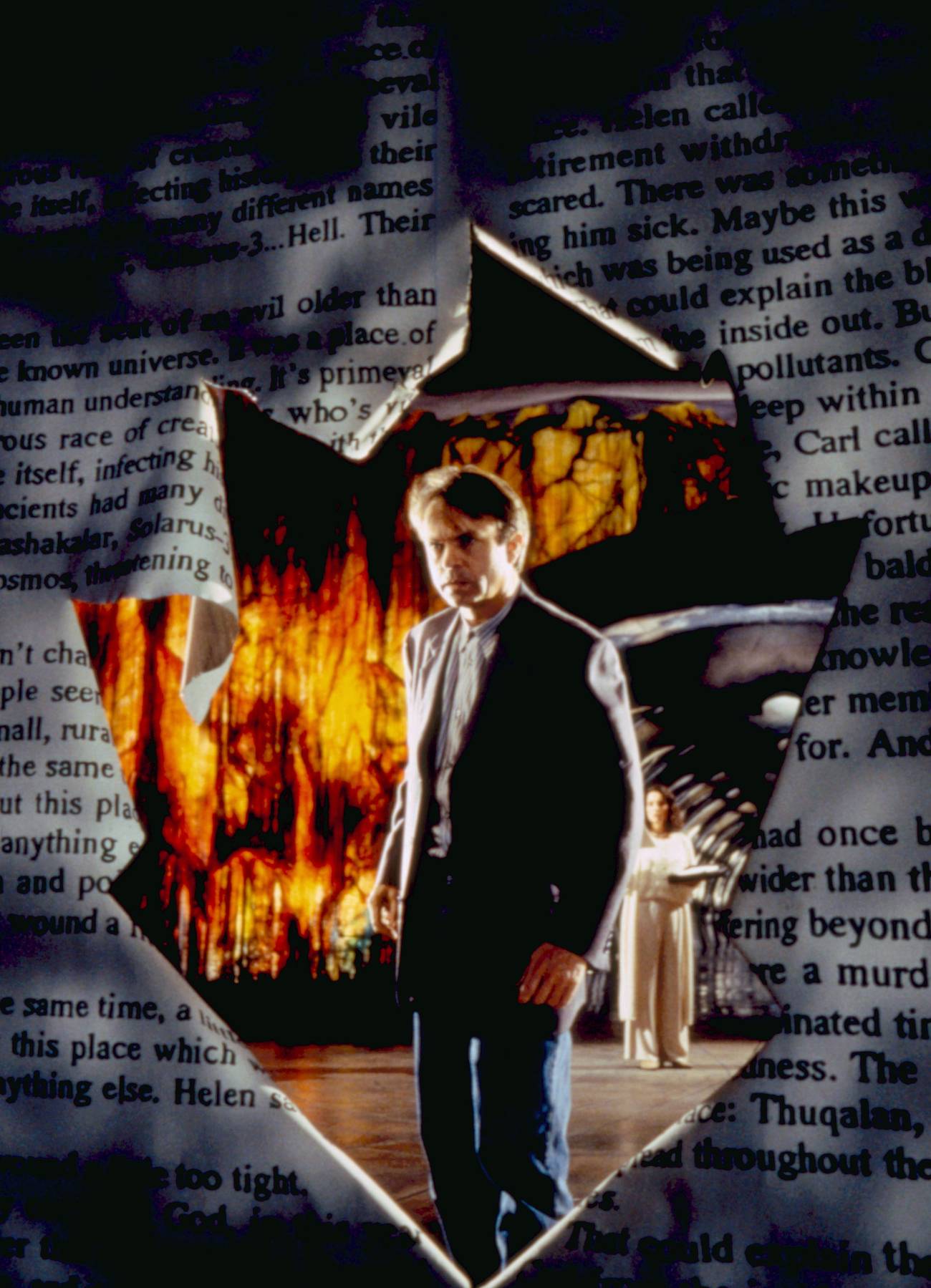 Sam Neill looks through a tear in a giant book page