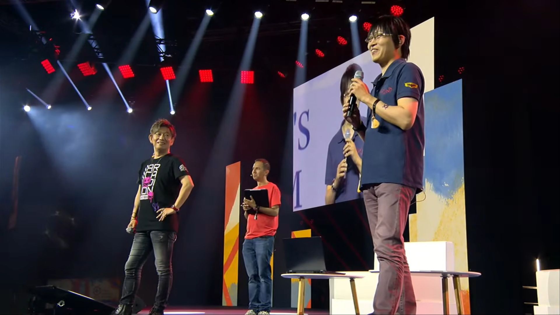 hamaguchi and yoshida standing at panel