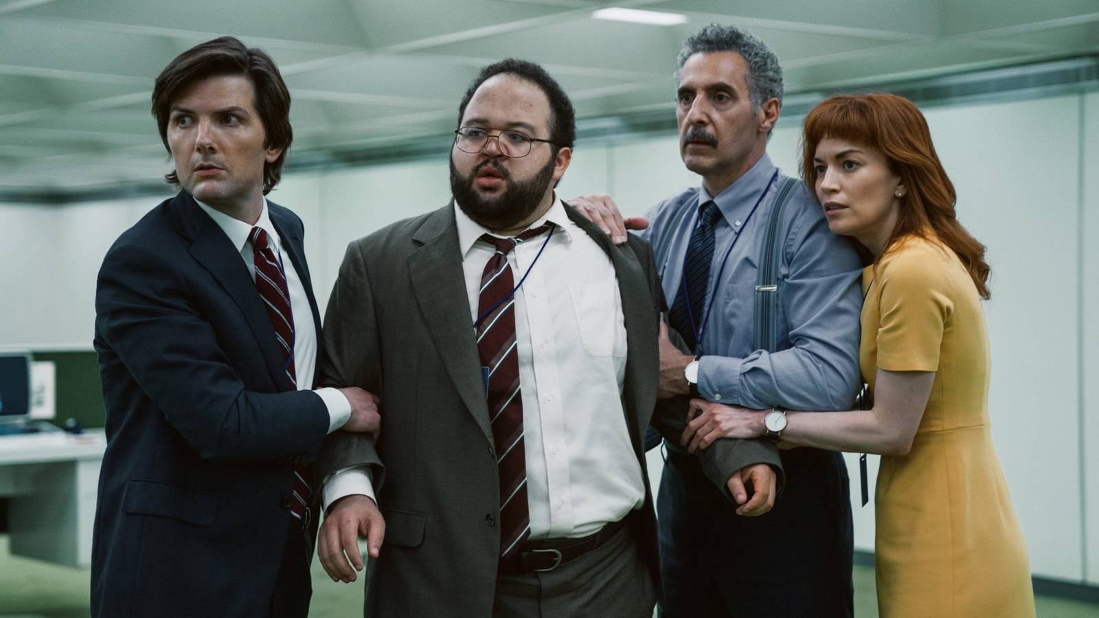 The innies of Severance gathered together and restraining Dylan