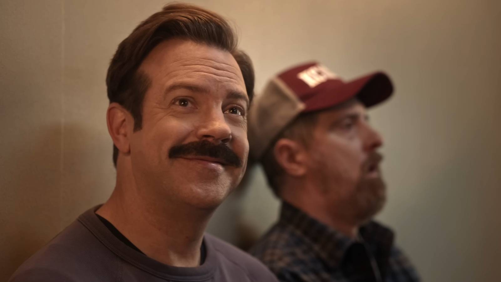 Ted Smiling while Beard lets out an exasperated sigh in the background.