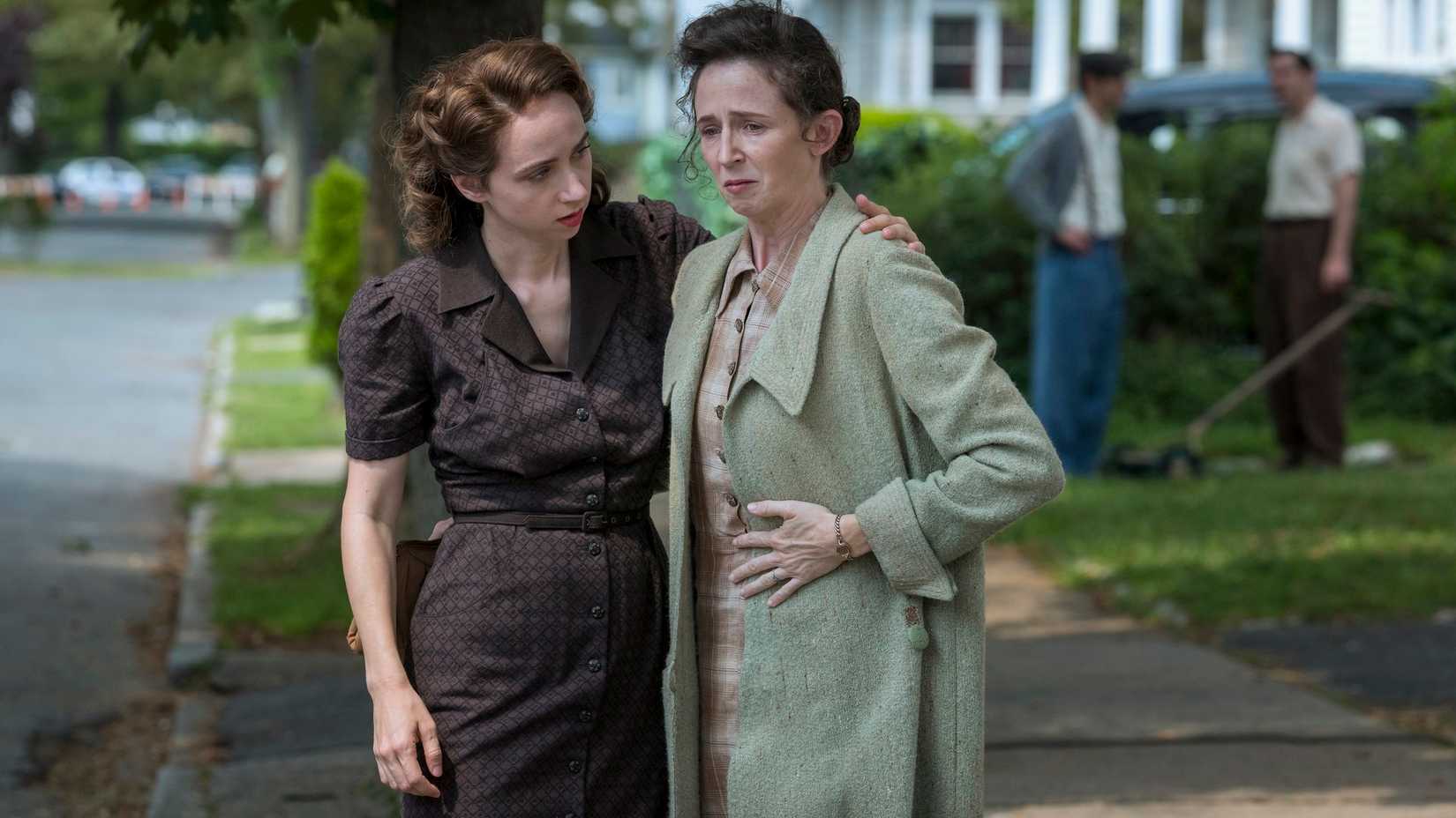 Bess Levin (Zoe Kazan) comforts Selma Wishnow (Kristen Sieh) who seems on the brink of tears as they stand on a suburban lawn in The Plot Against America.