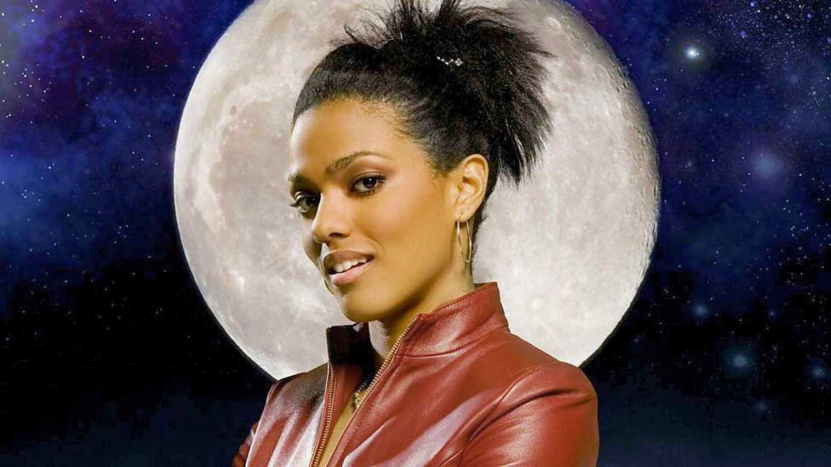 Martha Jones (Freema Agyeman) wears a red jacket. Behind her is a moon and stars.