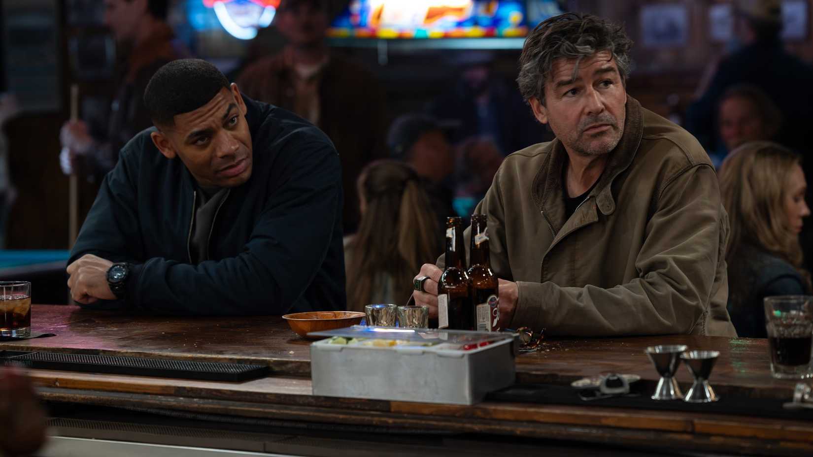 John Stewart (Aaron Pierre) and Hal Jordan (Kyle Chandler) sit at a bar in Lanterns