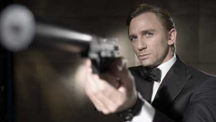 Daniel Craig as James Bond pointing a silenced pistol.