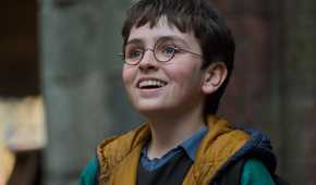 Dominic McLaughlin as Harry Potter in the HBO show smiling with his glasses on